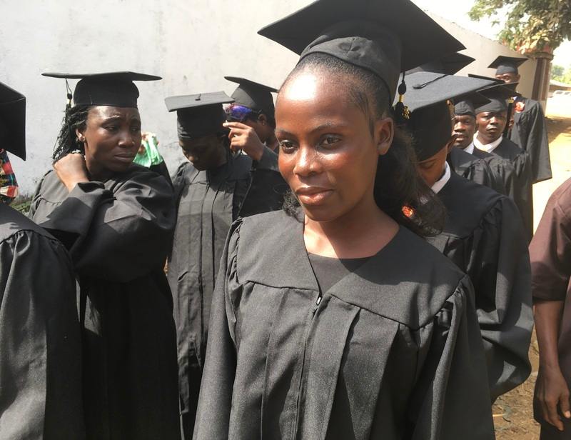 A young woman in a graduation robe.