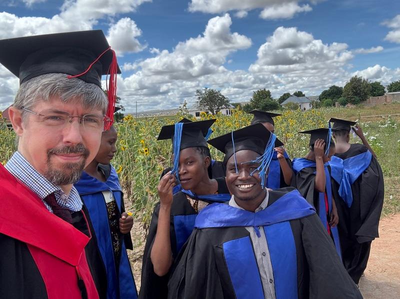 some sudents and a professor in graduation robes